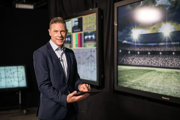 Mann mit Anzug, Tablet in der Hand in einem Stadion