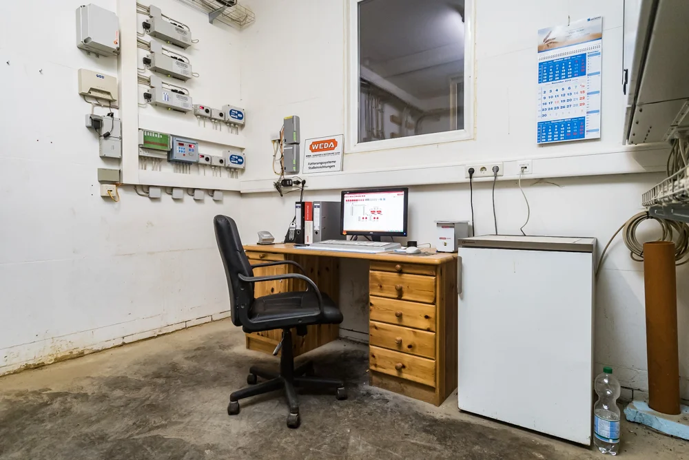 Holzschreibtisch mit Schubladenschrank und Bürostuhl in eine Weißen Raum mit Fenster