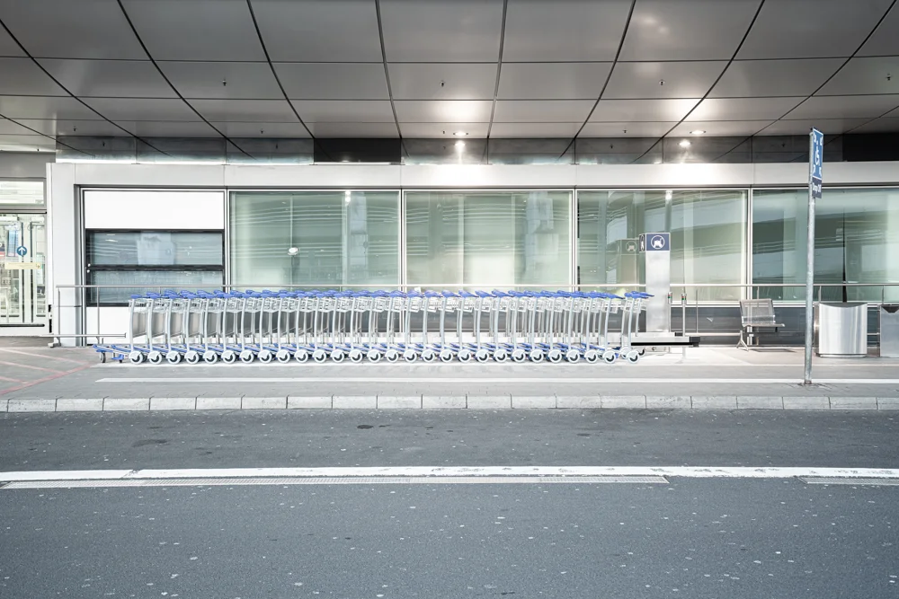 eine Schlange an Einkaufswagen vor einem Gebäude neben einer Straße